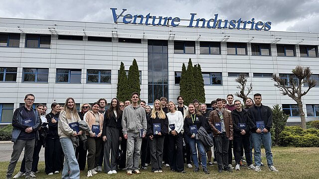 Uczestnicy wyjazdu edukacyjnego pozują do wspólnego zdjęcia przed budynkiem Venture Industries