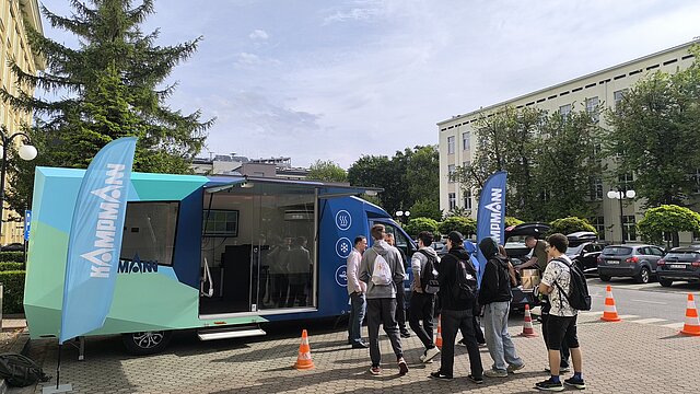 Studenci przy mobilnym centrum demonstracyjnym Kampmann na terenie uczelni.